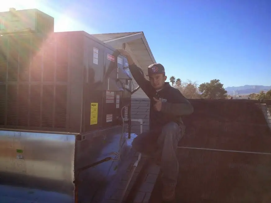 HVAC technician performing AC Tune-Up on a rooftop unit in Struthers